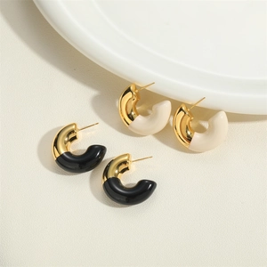 Polished C-shape gold-plated earrings with black and white enamel drip design