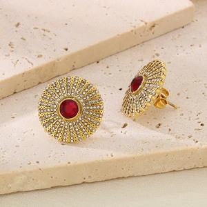 Detail of gold titanium sunflower stud earring with red stone and white zircons on stone