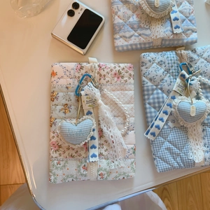 Detail of blue floral quilted makeup bags with zipper, lace trim and pearl handle