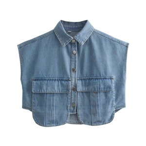 Dettaglio di gilet corto in denim azzurro con tasche anteriori e bottoni metallici