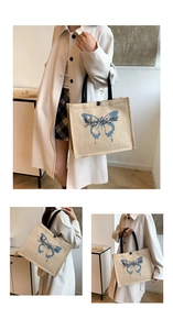 Detail of linen tote bag with blue butterfly print, black handles and button closure