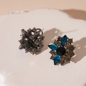 Detailed close-up of vintage flower earrings with crystal petals on a stone base