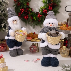 Close-up of Santa and snowman plush dolls holding baskets with sweets and cookies