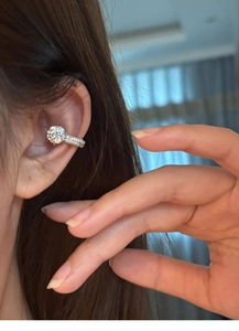 Close-up of a silver zircon ear cuff worn on the ear bone with a sparkling main stone