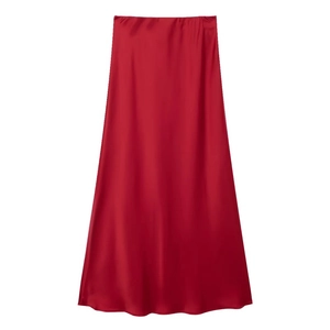 Flat lay detail showing the silky satin texture and drape of a vibrant red midi skirt