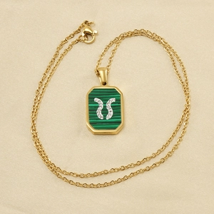 Gros plan d'un collier en acier inoxydable doré 18K avec malachite et cristaux