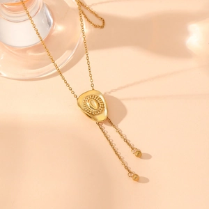 Golden stainless steel sweater chain with textured irregular pendant and tassel spheres