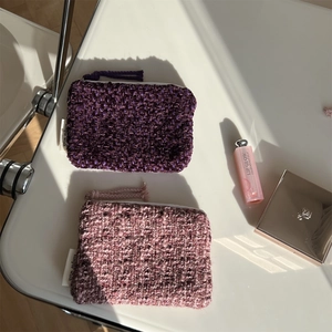 Close-up of purple and pink tweed mini storage bags with zipper and tassel details