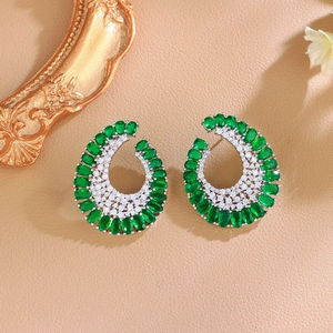 Detail of C-shaped silver earrings featuring oval green stones and pavé set zircons