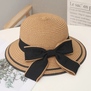 Vista ravvicinata di un cappello di paglia estivo con un grande fiocco nero