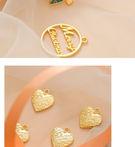 Close-up of golden metal wedding charms with Merry Christmas and Made With Love engraving