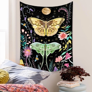 Detail of bohemian tapestry featuring golden butterfly and moon patterns on a black background