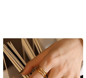Détail d'une bague multicouche plaquée or portée à l'index avec un style rétro chic