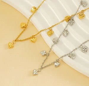 Detailed macro view of gold and silver heart charms on stainless steel link chains