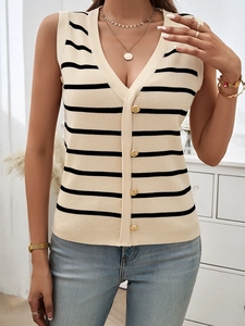 Dettaglio del gilet in maglia con scollo a V, righe nere e bottoni dorati