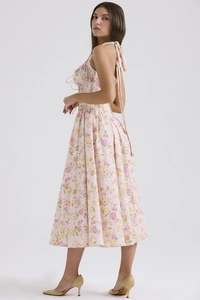 Detail of pink floral midi dress showing the lace-up shoulder straps and waist design