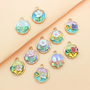 Close-up of colorful enamel flower charms with gold edges for DIY jewelry making