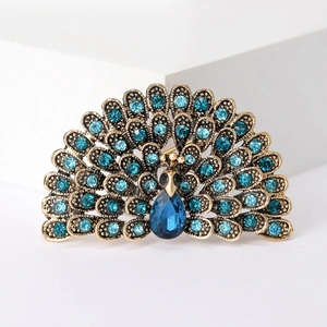 Macro detail of vintage peacock brooch featuring blue rhinestones on antique gold metal