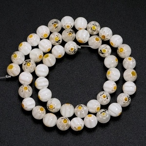 Macro detail of ivory millefiori glass beads with yellow floral pattern and ribbed texture