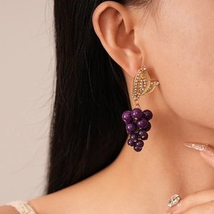 Détail des boucles d'oreilles grappe de raisin violet avec feuilles en strass