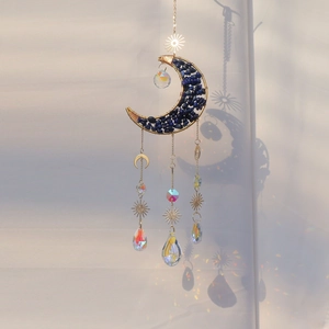 Detail of moon-shaped crystal suncatcher with blue stones and rainbow prisms