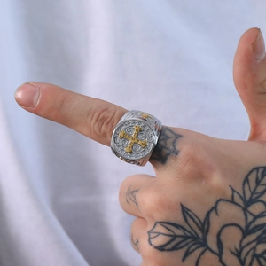Detail of Saint Benedict medal cross ring in silver and gold on a male hand