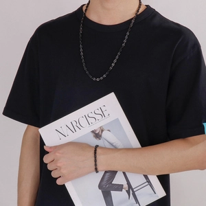 Close-up of a stylish men's black stainless steel chain necklace and bracelet jewelry set