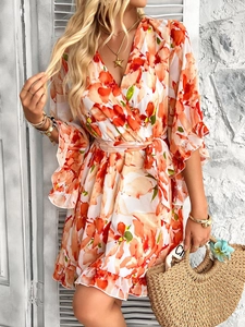 Detail of short ruffle sleeves and V-neck wrap design on orange floral chiffon dress