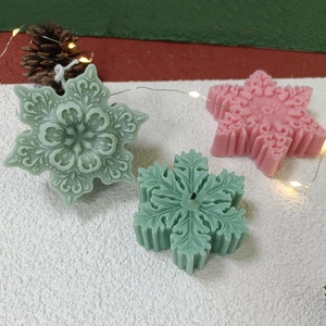 Handmade 3D snowflake scented candles in festive colors with detailed floral relief pattern
