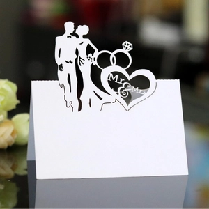 Laser cut white wedding place cards with Mr & Mrs heart silhouette and ring design