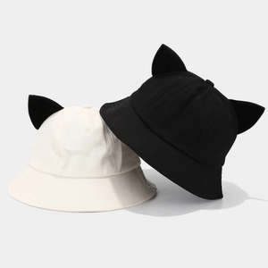 Close-up of cute cotton bucket hats with devil ears in beige and black colors