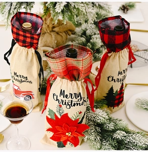 Macro shot of linen Christmas wine bottle bags with poinsettia and truck patterns