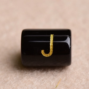 Black cylindrical bead with gold glitter letter J for DIY jewelry making and crafts