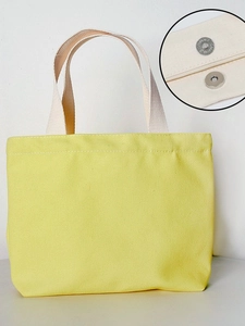 Solid yellow canvas tote bag with magnetic closure and beige handles for daily commute