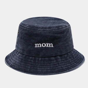 Dettaglio del ricamo mom e occhielli metallici sul cappello a secchiello blu lavato