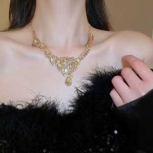 Detailed view of luxury gold necklace with teardrop pendant and crystal embellishments