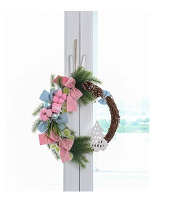 Close-up of macaron color Christmas wreath with velvet bows and pine cones on window