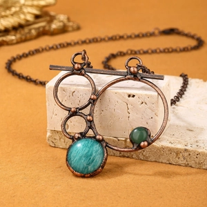Vintage bronze necklace with geometric Amazonite and Labradorite pendants on stone