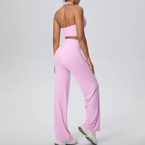 Detail view of backless pink yoga set featuring a halter crop top and high-waisted wide-leg pants