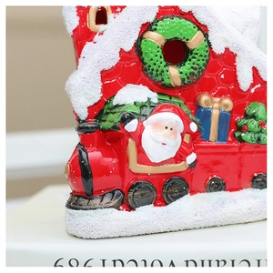 Close-up of a red ceramic Christmas train with Santa Claus and realistic snow details