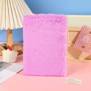 Pink plush A5 notebook with soft faux fur cover on a stylish pastel desk setup