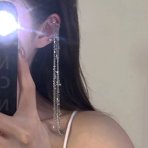Close-up of sparkling silver star tassel earrings with zircon studs for women