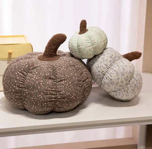 Detailed close-up of three floral pumpkin pillows in brown, green and blue quilted fabric