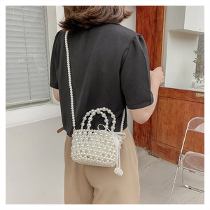 Détail du sac panier en perles tressées avec poignées et un nœud en ruban de soie