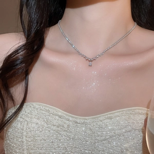 Close-up of a silver water drop pendant necklace with zircon stones on a model's neck
