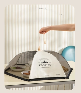 Détail d'une cloche alimentaire pliable avec cordon de serrage et motif décoratif
