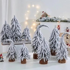 Close-up of mini PE Christmas trees with artificial snow flocking on natural wood bases