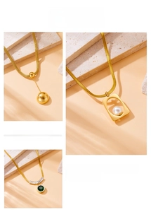 Detail of gold layered necklaces with pearl, emerald pendant and snake chain links