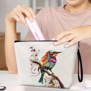 Linen makeup bag with colorful bird illustration and black wrist strap for travel
