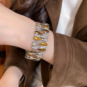 Close-up of a vintage wide stretch bracelet with silver base and amber resin inlay on wrist